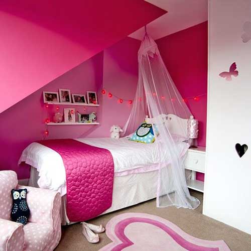 Quarto de menina rosa e branco com paredes decoradas