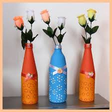 Garrafas decoradas com cores diferentes e com duas flores cada