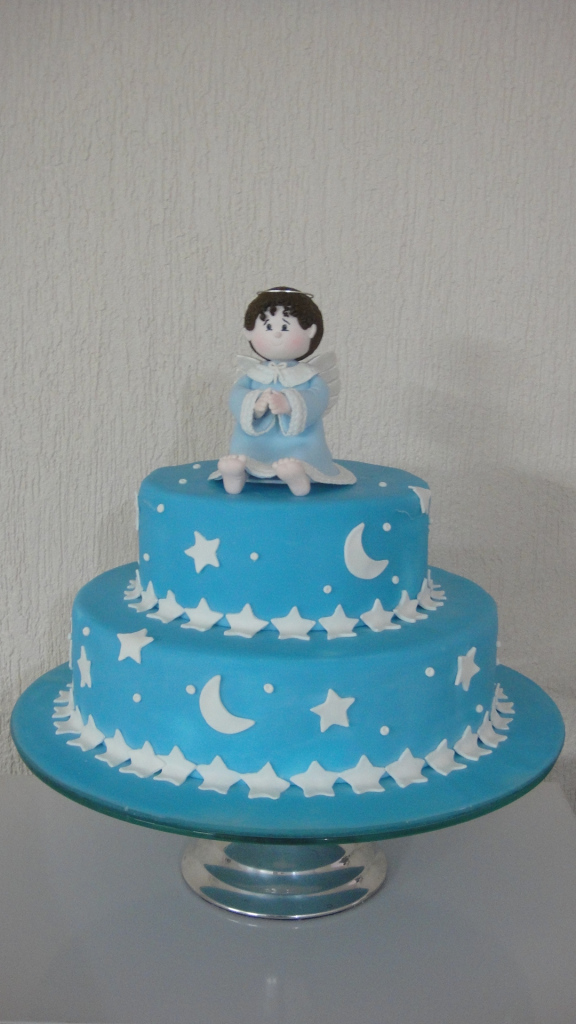 Azul com detalhes em branco decorando um bolo com boneco em cima
