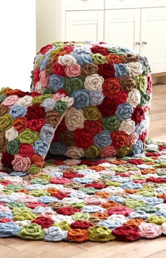 Muitas flores de croche em um mesmo tapete com diversas cores