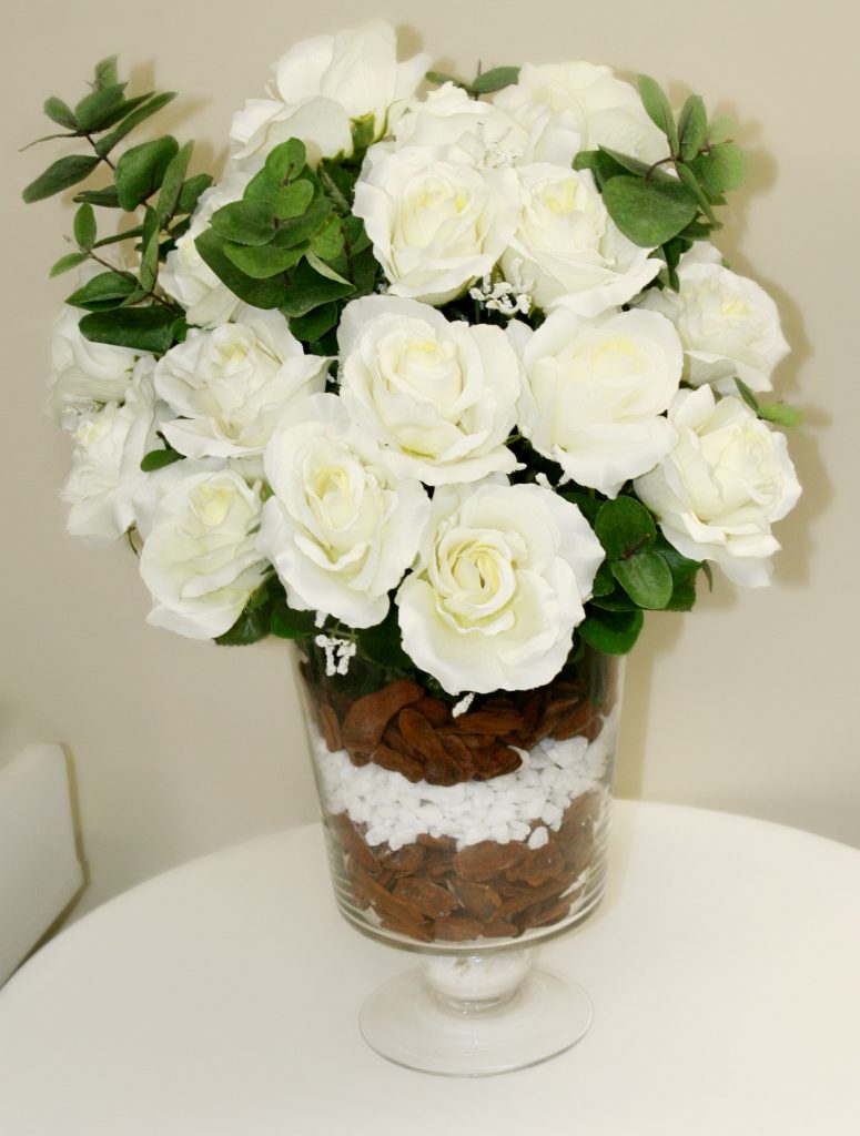 Rosas brancas com fundo do vaso em pedras