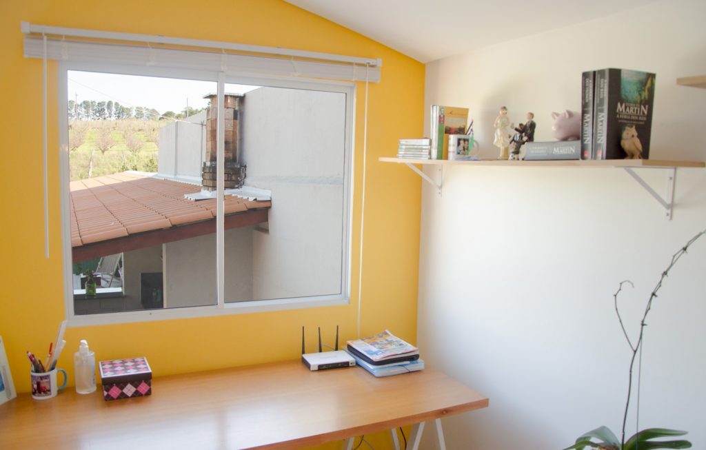 Janela com persiana em uma parede amarela no seu quarto