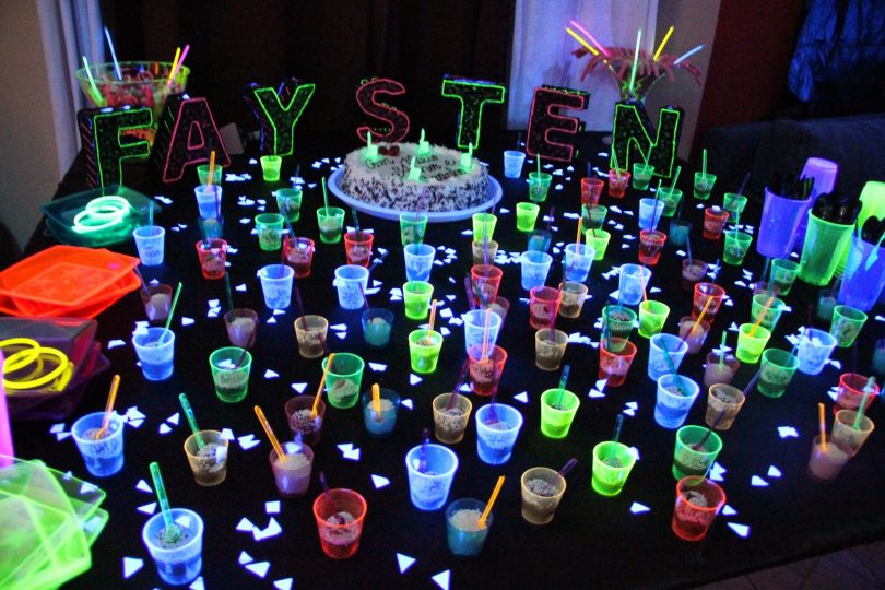 Linda mesa de festa com decoração iluminada por neon