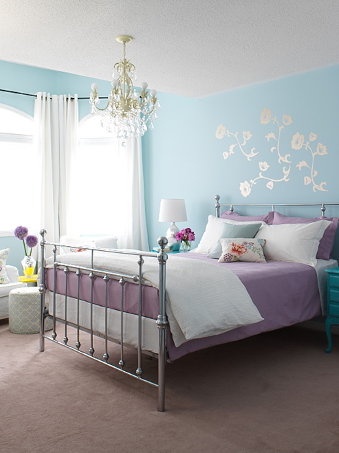 Parede azul com roupa de cama em lilás na decoração do quarto
