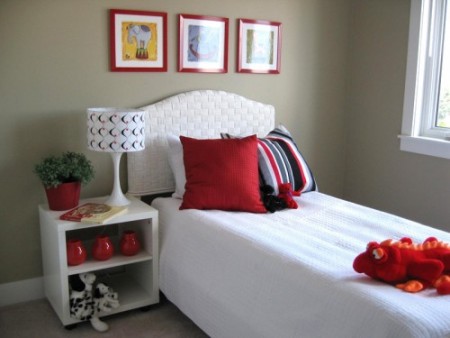Quarto com decoração branca na cama e almofadas vermelhas para complementar