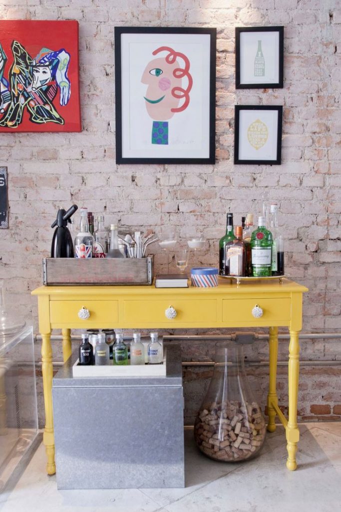 Pequeno bar em casa com mesa amarela