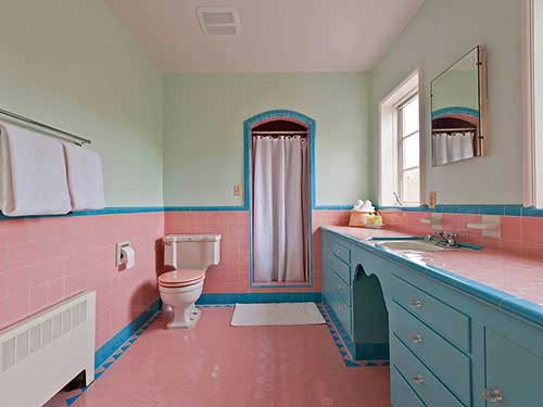 um banheiro feminino com cerâmica rosa no piso e parede