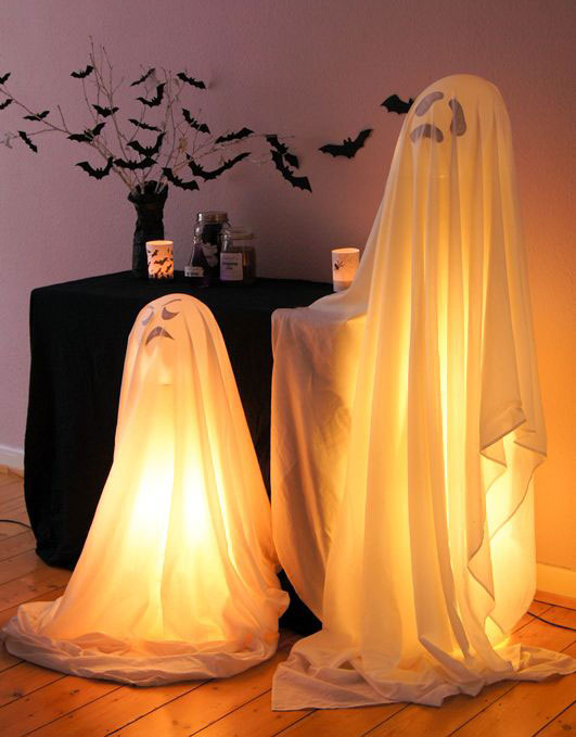 Decoração de halloween com fantasmas de lençol e luzes