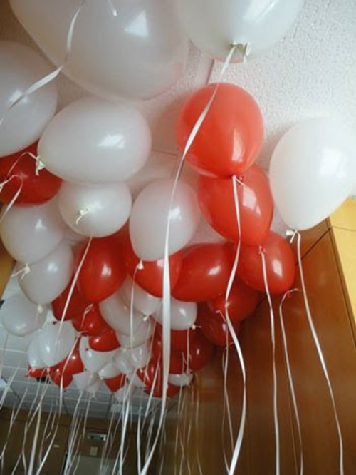 Balões vermelhos e brancos pendurados no teto para decoração de natal