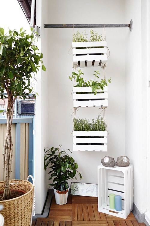 Caixa de madeira branca na parede como porta plantas em trio