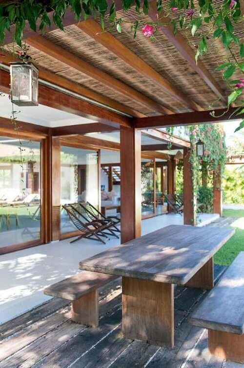pergolado de bambu mesas e folhagens no patio de casa